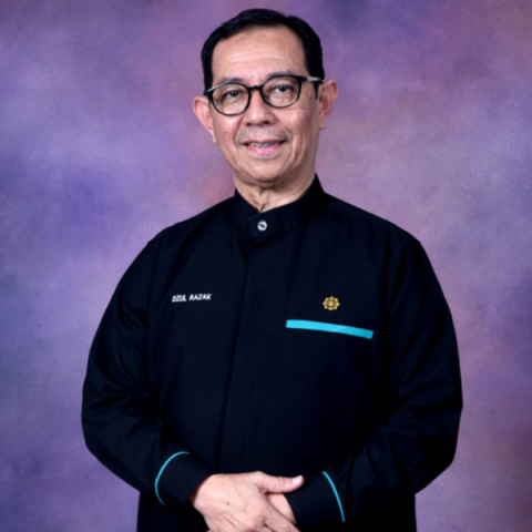 Headshot of Dzulkifli Abdul Razak smiling to camera with hands crossed