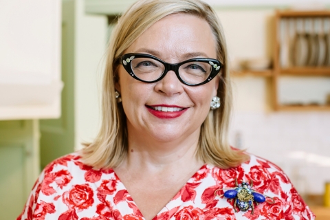 photo of a smiling Deborah Sugg Ryan in a lovely red dress