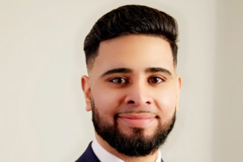 Headshot of Haris Kiani smiling to camera with beard wearing suit