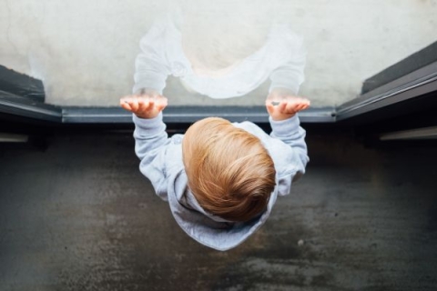 Overhead view of young boy standing in front of window