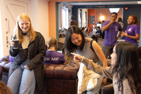 International students are chatting and laughing in a café.