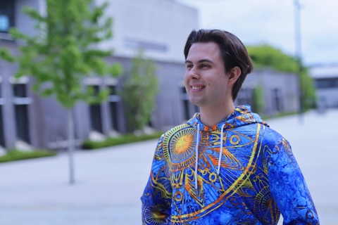 Student wearing colorful hoodie and smiling.