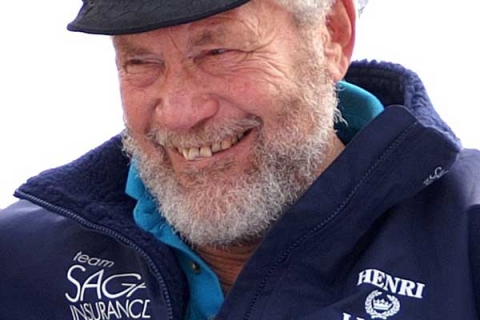 Sir Robin Knox-Johnston smiling to camera wearing cap