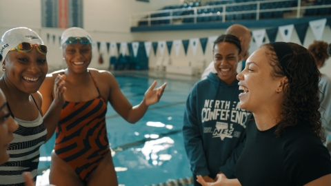 Seren Jones at a swimming pool laughing with fellow swimmers