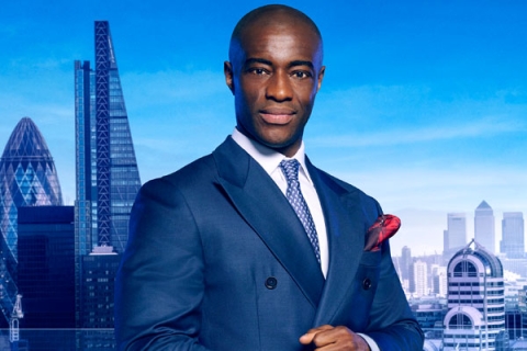 Headshot of Tim Campbell MBE looking to camera wearing blue suit with London backdrop
