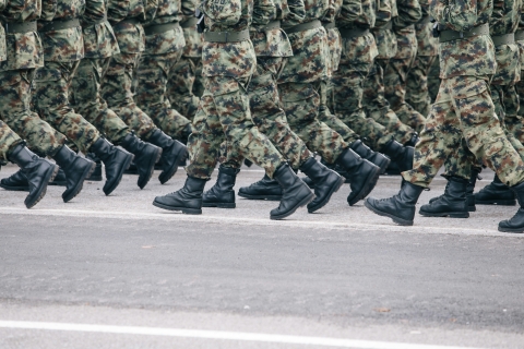 Soldiers dressed in army camouflage march in formation