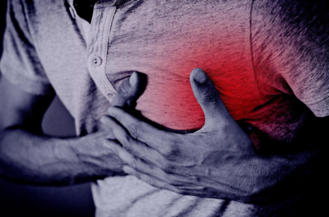 A man holding his heart tightly as if in pain