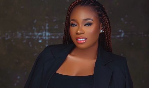 Jenny smiling at the camera wearing a blazer