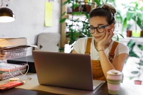 woman in glasses looking at a screen 