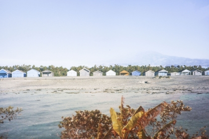 a photo of beach huts by the sea - by lauren lawler