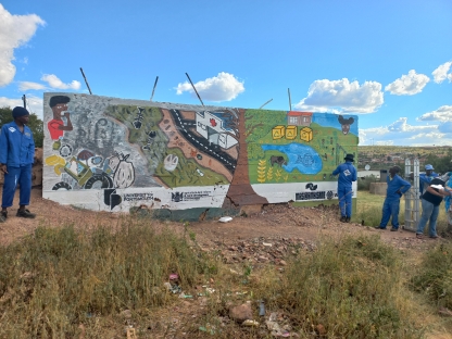 The completed mural in front of a bright blue sky