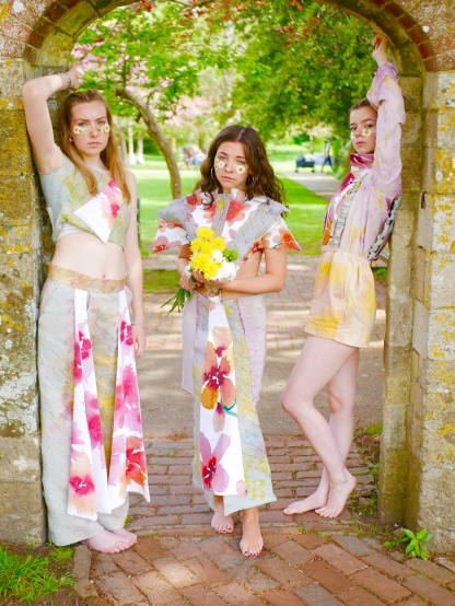 3 students wearing garments in an archway