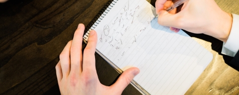Close up of a notepad while a person takes notes in shorthand