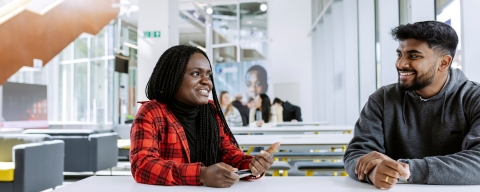 Two students sitting together and talking in the Eldon seating area