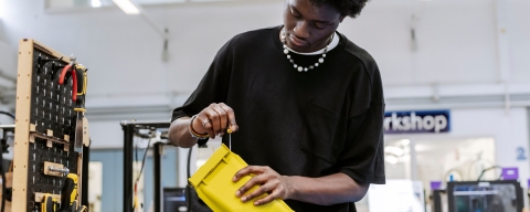 Student using screwdriver on yellow plastic component.Technology Facilities Day One