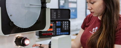 Female student operating cutting bench.Technology Facilities Day One - NOT FOR THIRD PARTY - CONSENT