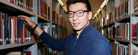 Creative writing student between bookshelves