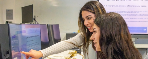 Two women collaborating on a computer 
