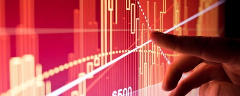 A hand gesturing to data on a screen