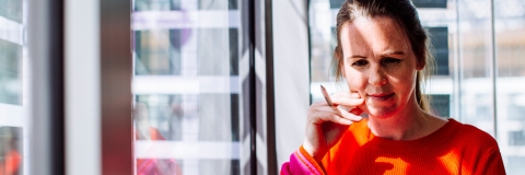 Student studying on laptop wearing orange jumper