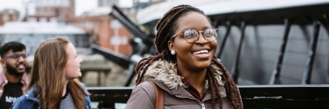 Female student smiling while passing by harbour