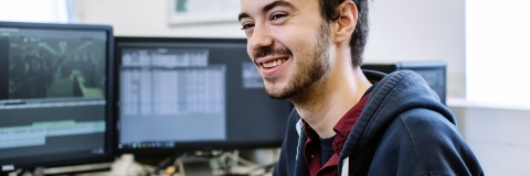 Smiling male student at computer