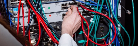 student inserting wire into computer server