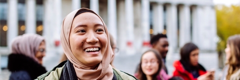 International students smiling and laughing outside Portsmouth Guildhall