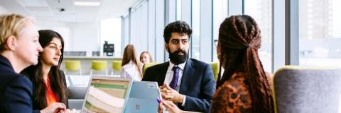 Four people sat round a table in a meeting
