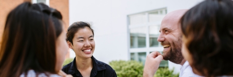 Group of people sat around a table, smiling and laughing