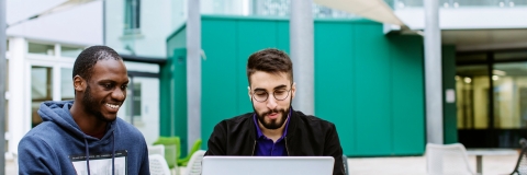 Students looking at a laptop outside Portland building