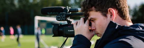 Ollie Marsh, journalist, filming a story