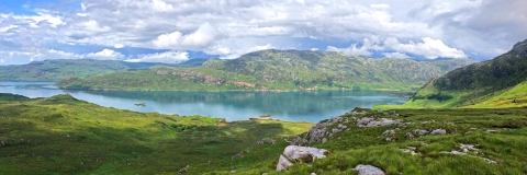 Image capturing a nature landscape with mountains, grass and a lake 