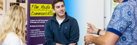 Student siting smiling infront of another person