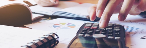 man using calculator at desk