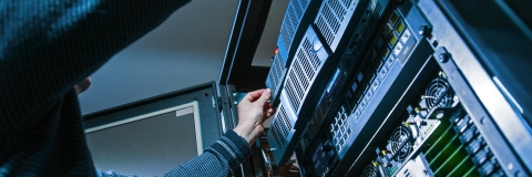 Information systems student reaches into server