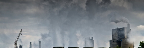 Pollution from factory rising into a dark grey sky