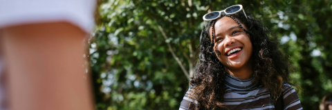 Student outside with sunglasses on smiling