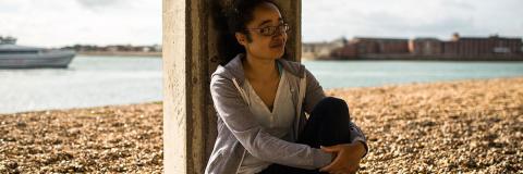 A female student from Malta sitting on the beach