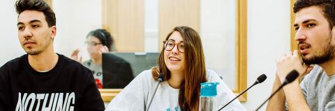 a male student from Portugal with friends in a debate