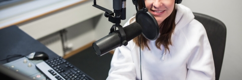 A student in a recording studio wearing headphones