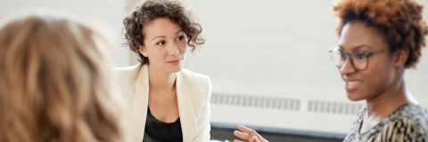 An academic talking to a student sat at a desk