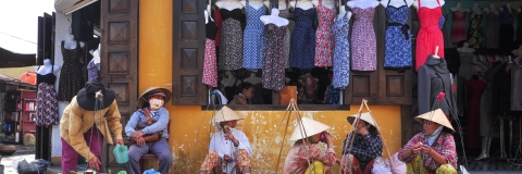 Asian women sitting on the floor at a market