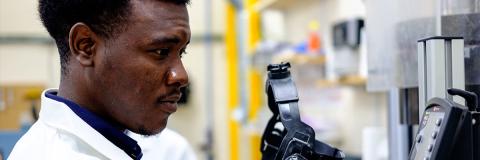 male student from Tanzania in geology lab