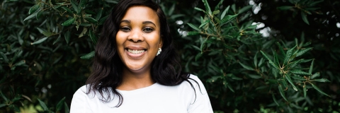 Student smiling with arms crossed in Ravelin Park