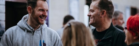 A member of University of Portsmouth staff smiling with some parents at an Open Day