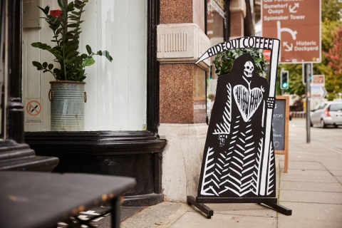 Grim Reaper Sign outside entrance of Hideout Coffee