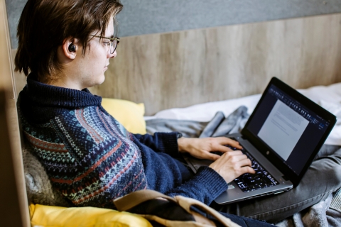 Student applying for UCAS on his laptop at home