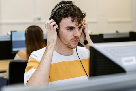 Student putting on headset in Digital Language Laboratory