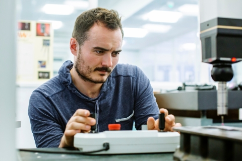 Student uses laser cutter in the metrology lab